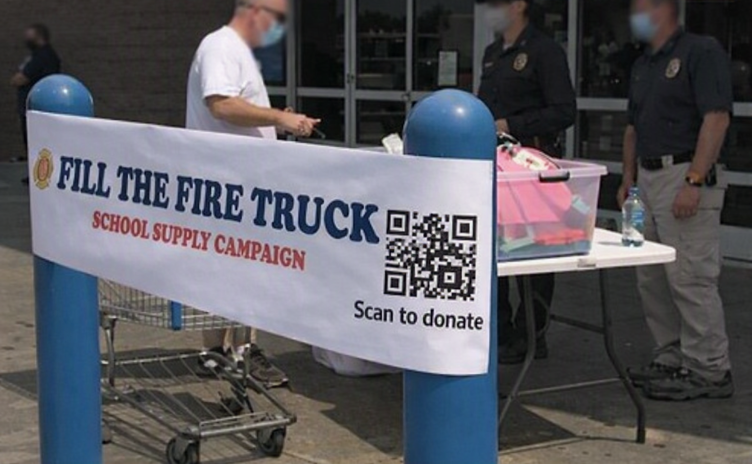 Fire crews raising school supplies with a scan-to-donate banner.